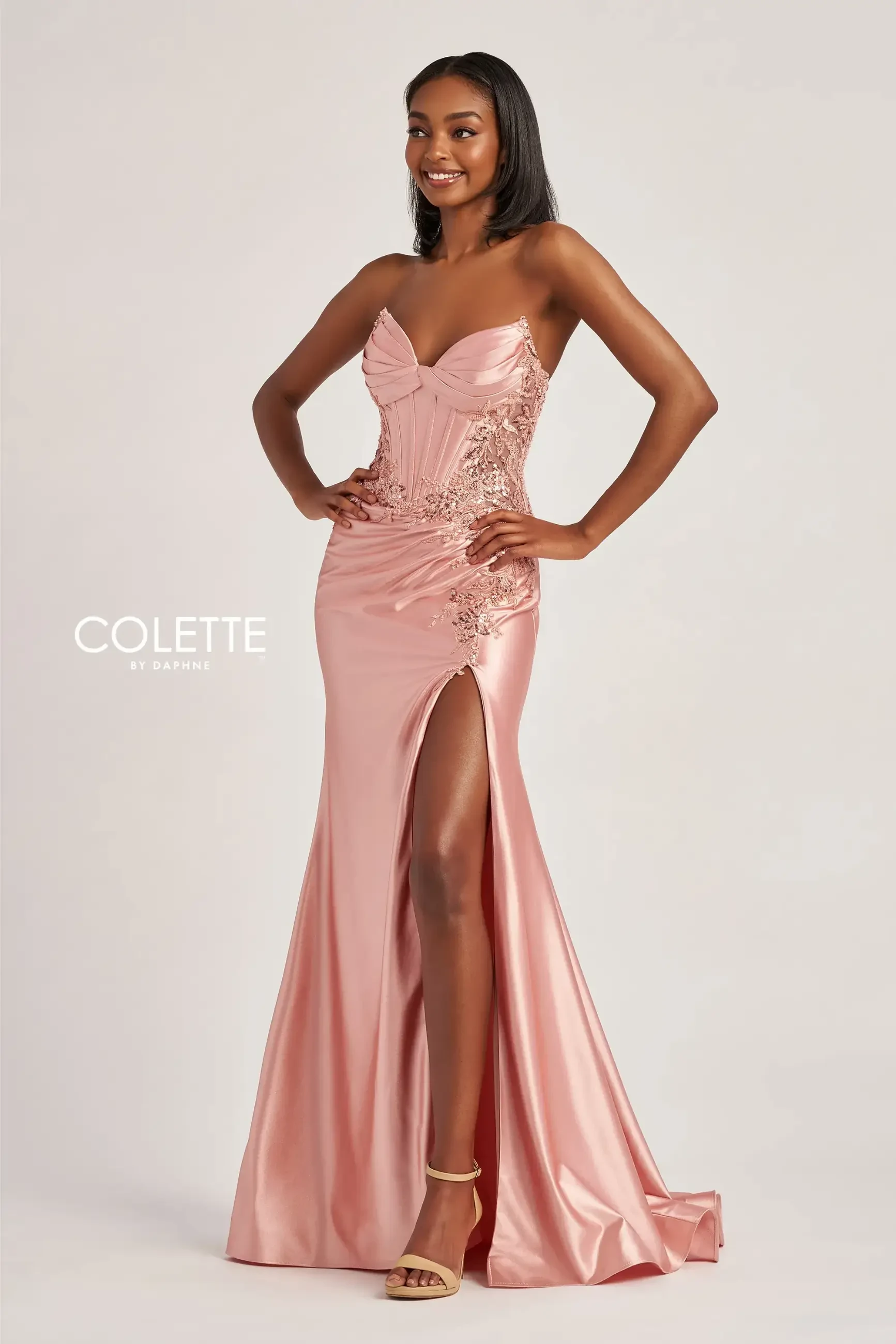model is wearing a rose gold metallic prom dress