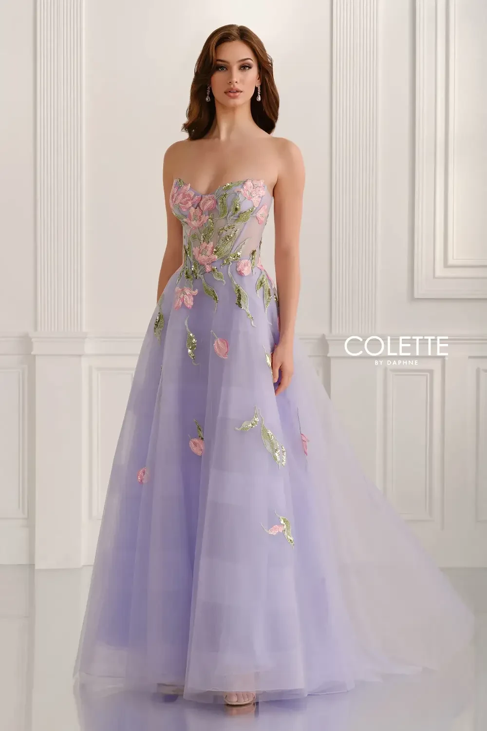 A woman wearing a strapless lavender gown with floral embellishments.