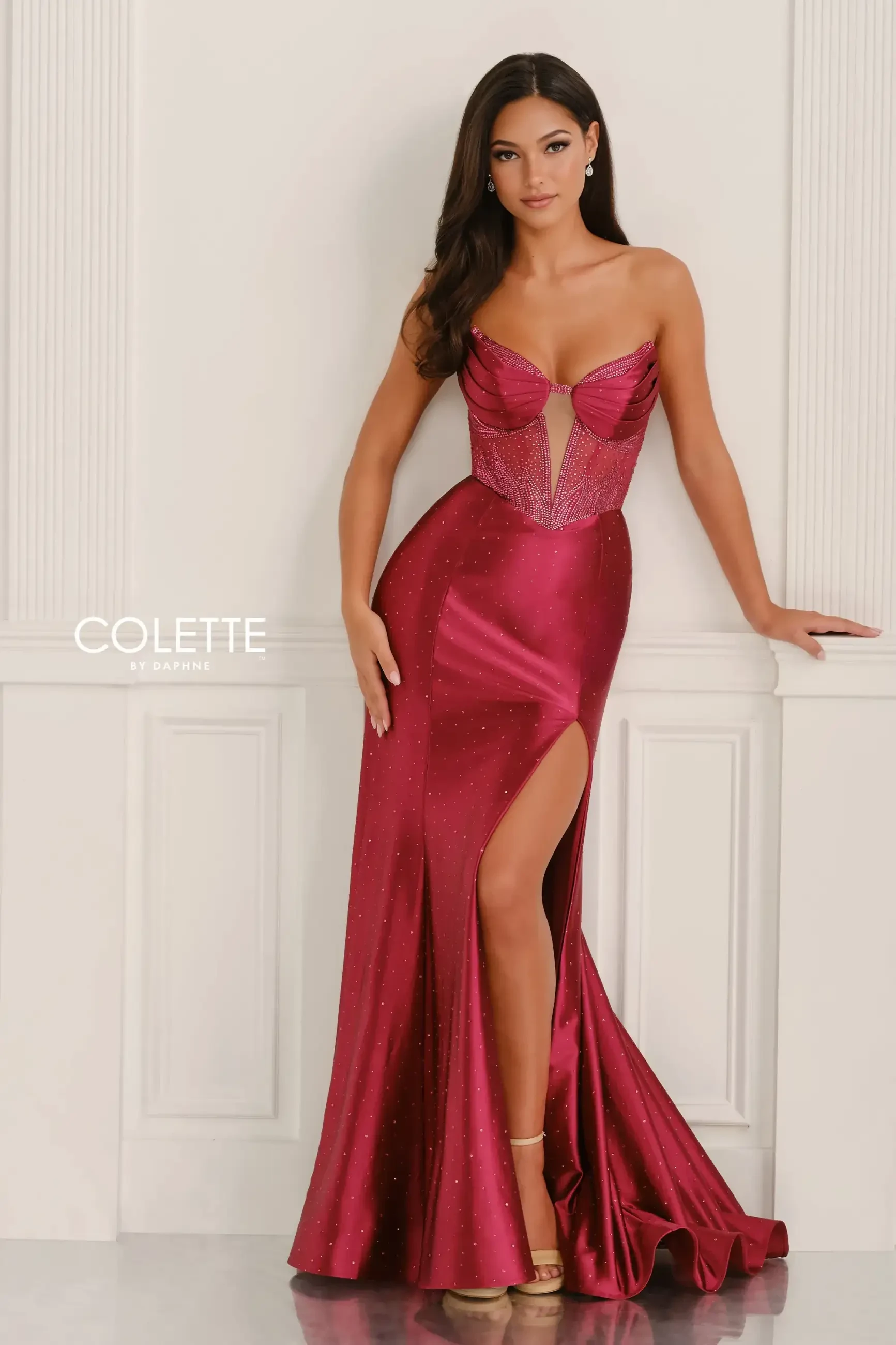 model is wearing a sleeveless burgundy prom dress