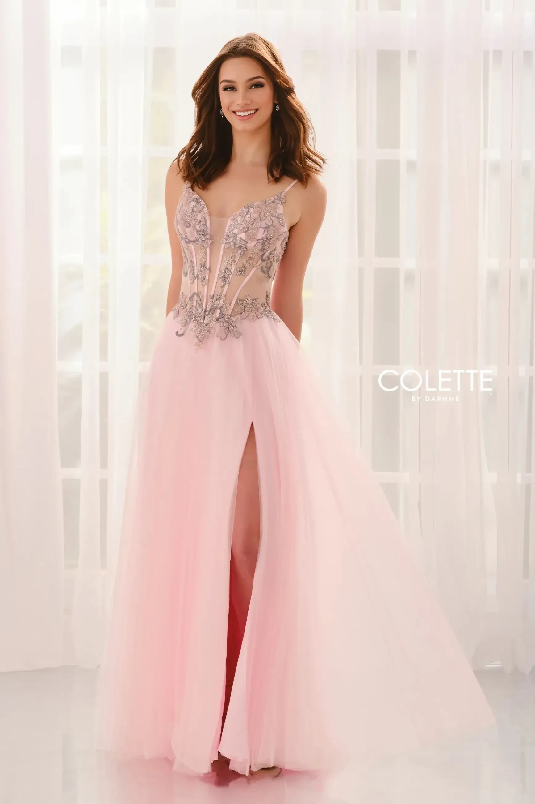 model is wearing a light pink a-line prom dress