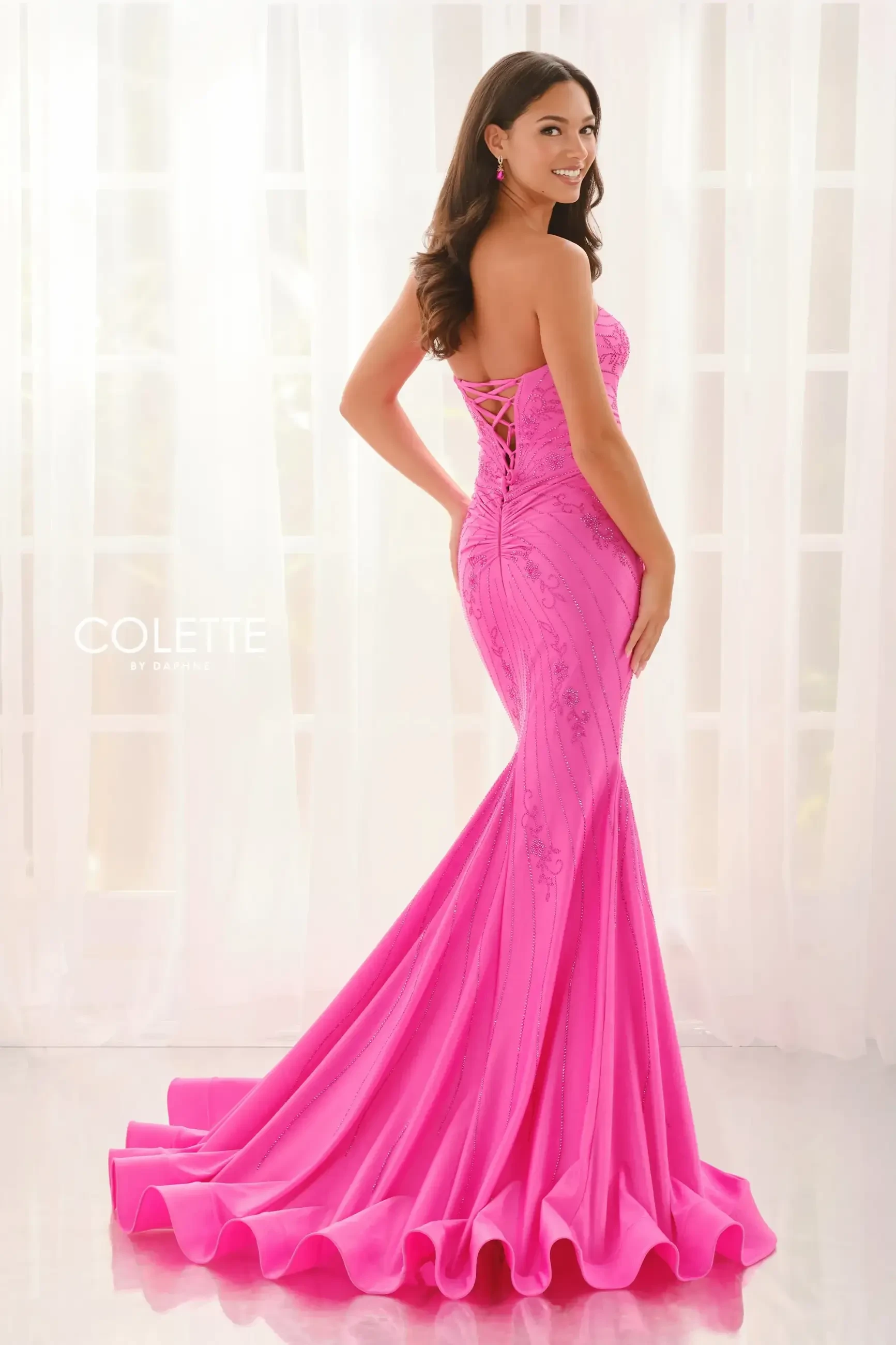 model is wearing a fuschia strapless prom dress
