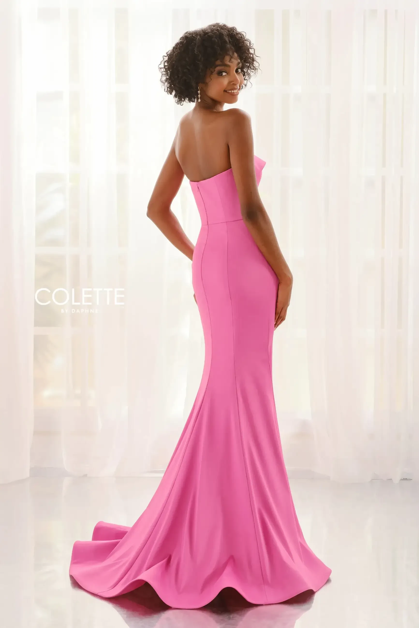 model is wearing a sweetheart pink strapless prom dress