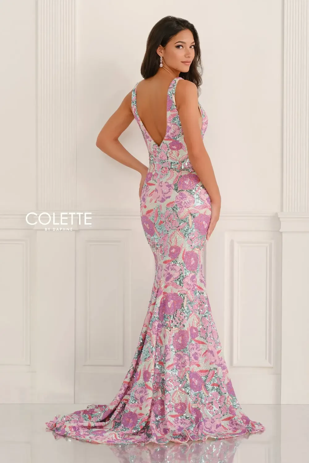 model is wearing a sleeveless floral open back prom dress