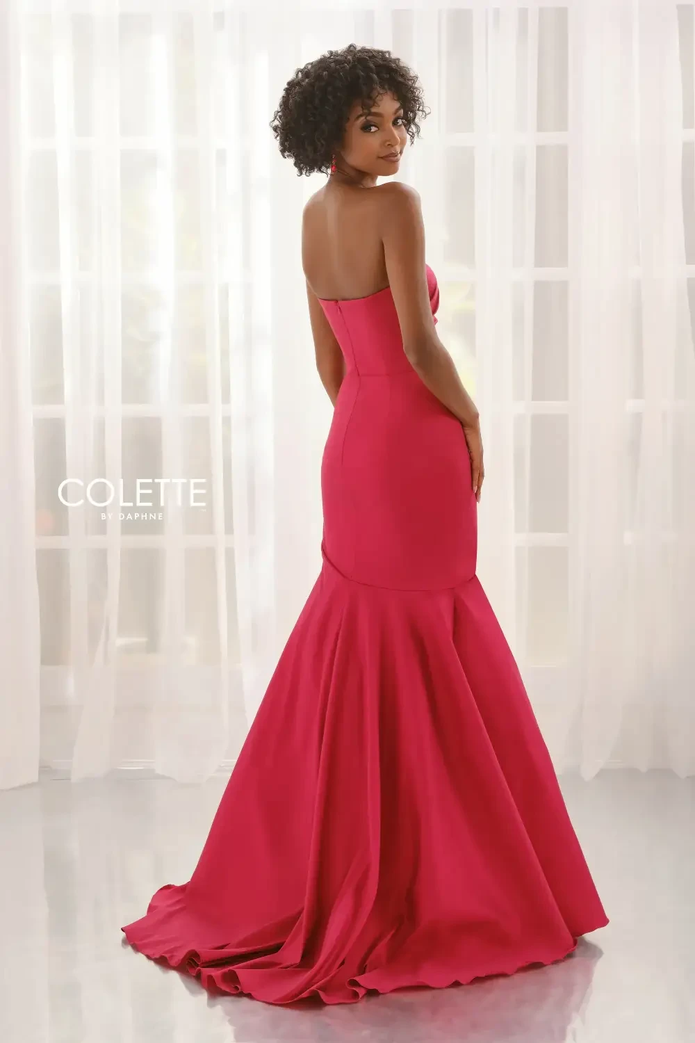 model is wearing a scarlet red strapless prom dress