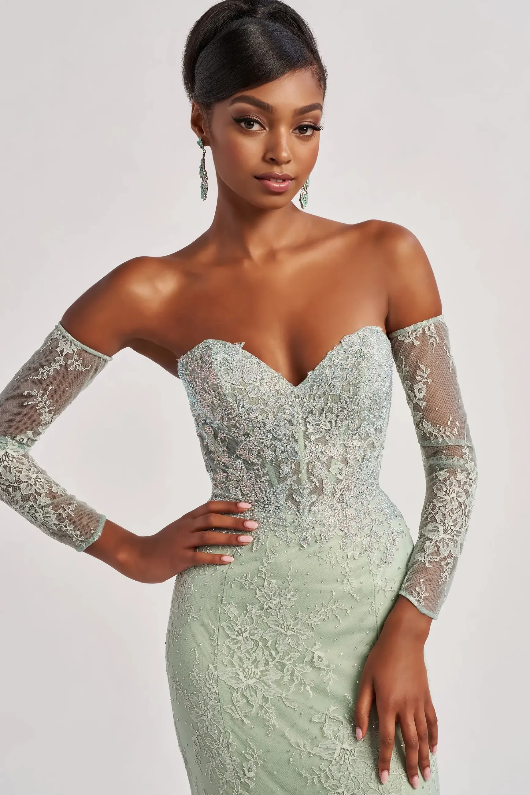 model is wearing a sleek sage prom dress 