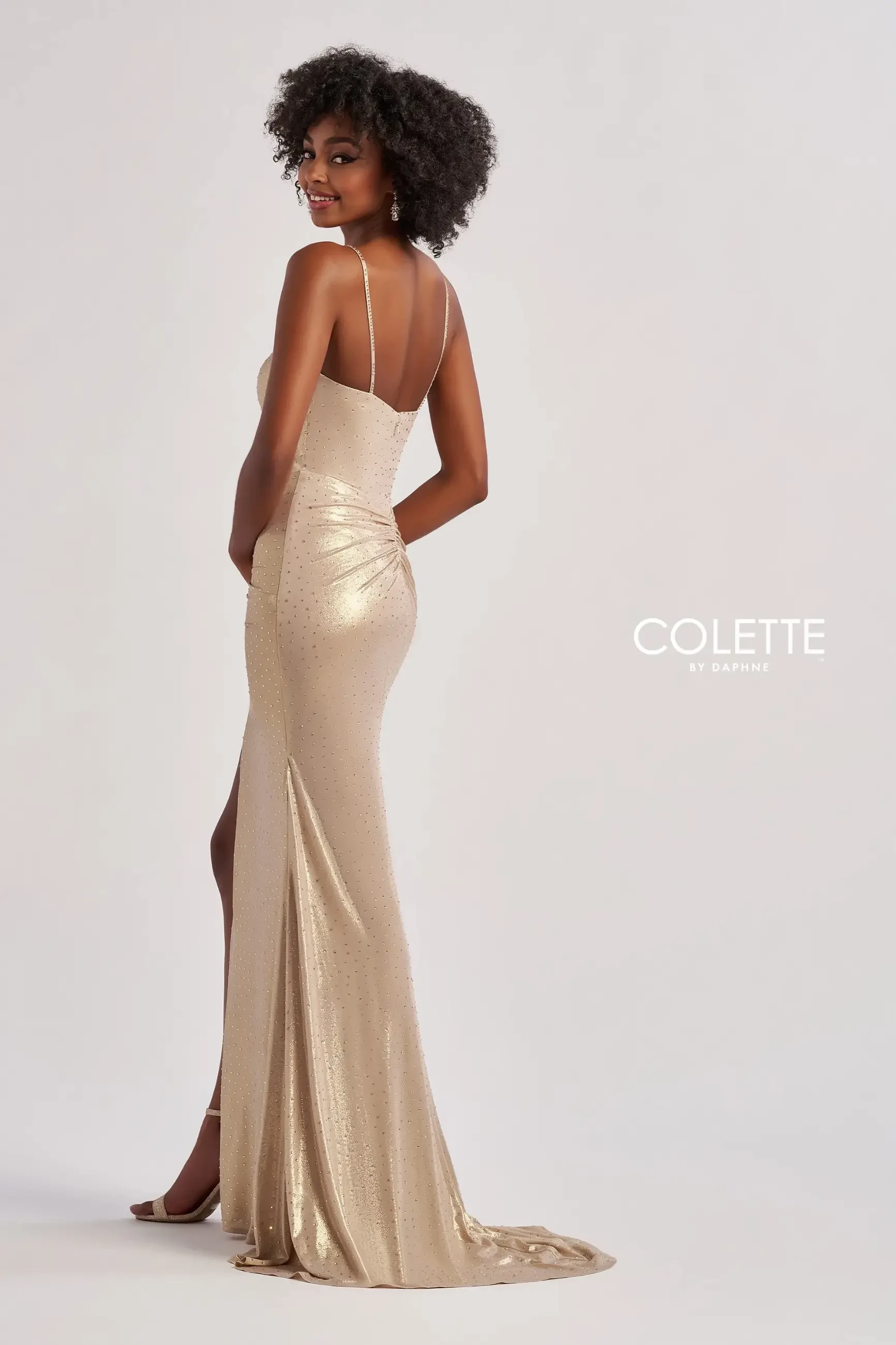 model is wearing a gold sleeveless prom dress