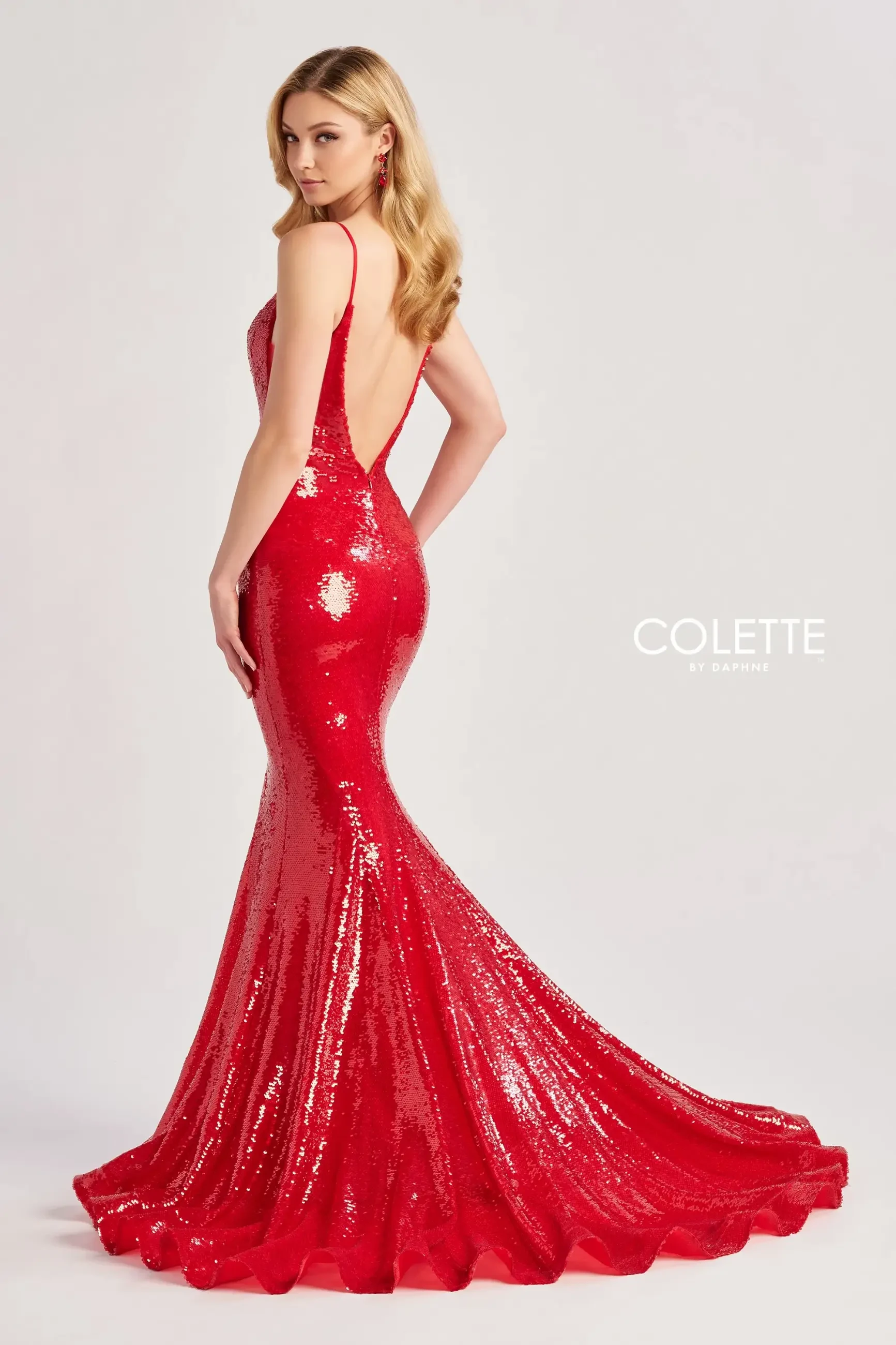 model is wearing a glamorous red prom gown
